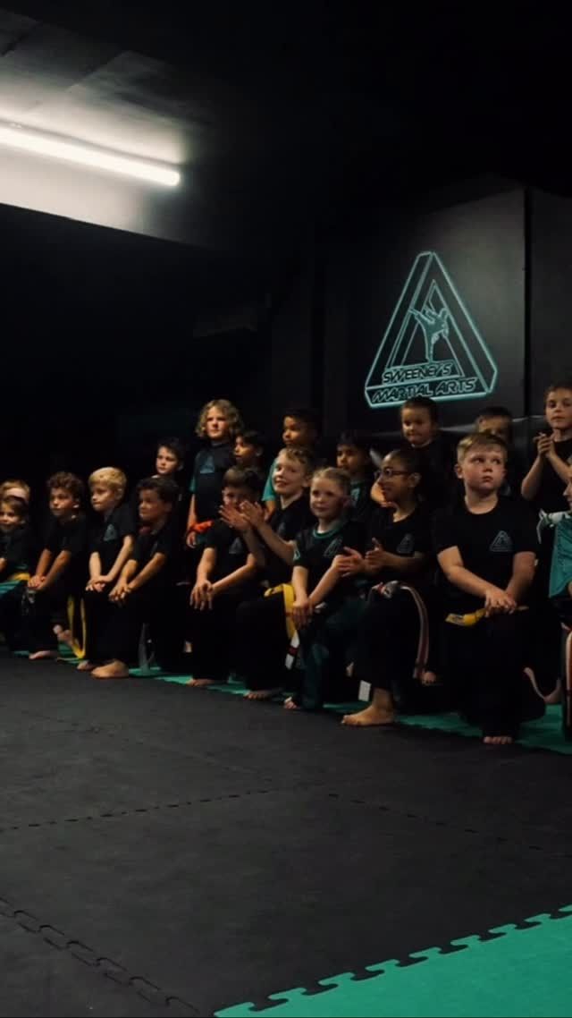 Sweeney’s students sitting together on the mats with their belts at a grading evening
