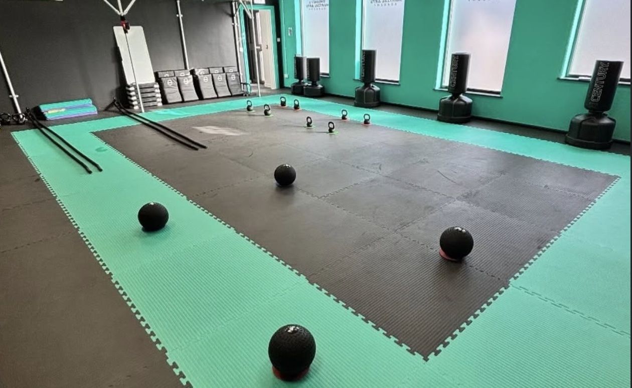 The Blitz room at Sweeney’s, with slam balls, kettlebells and battle ropes laid out on the mats